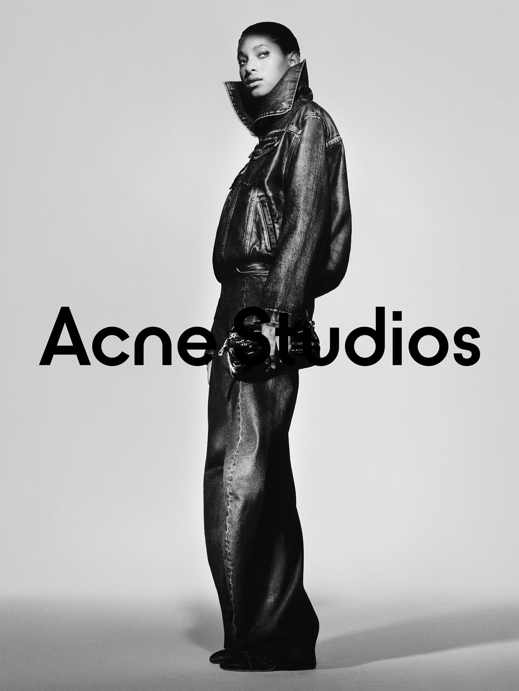 Willow Smith wearing Acne Studios denim jacket and pants against a plain studio backdrop