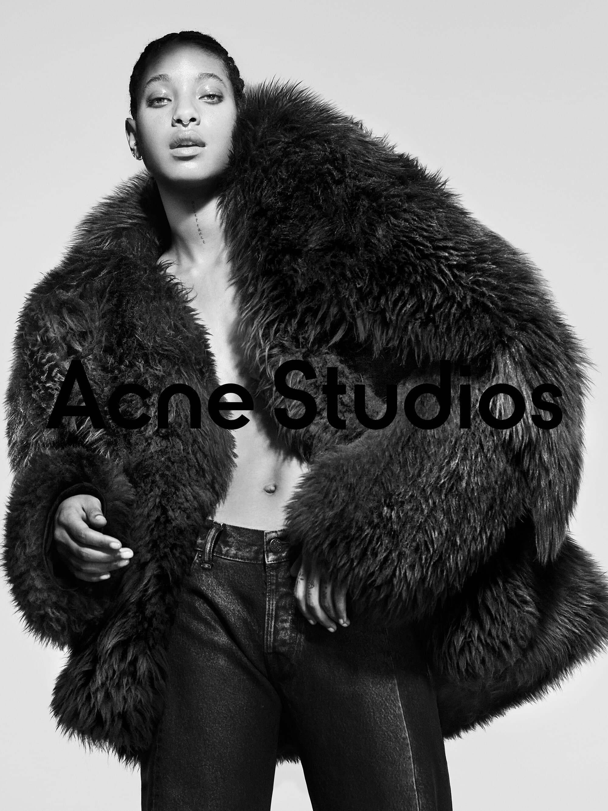 Willow Smith wearing a voluminous dark furry coat and dark jeans against a seamless light background for Acne Studios Fall 2024 campaign