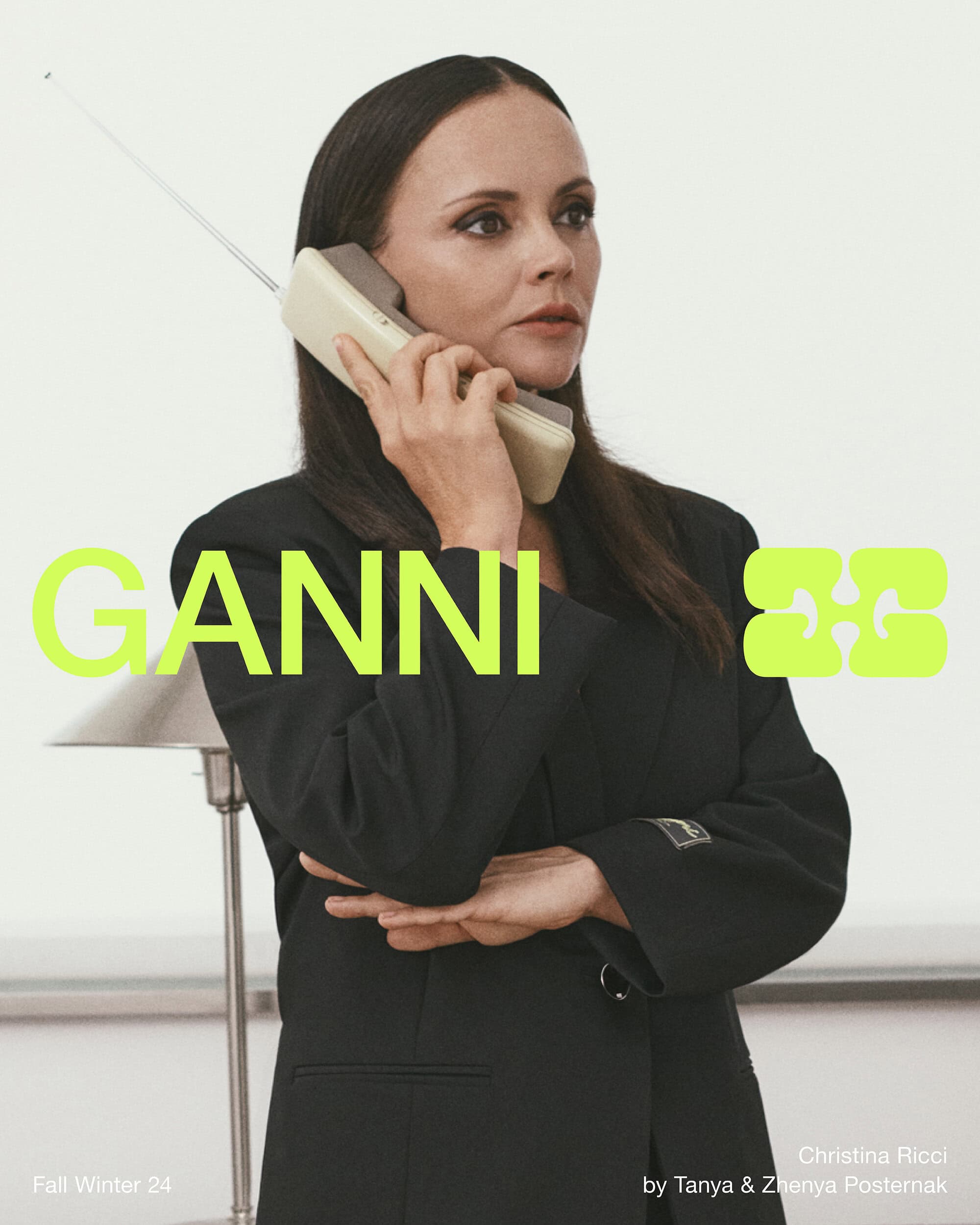 Christina Ricci holding a vintage mobile phone wearing a black blazer for Ganni