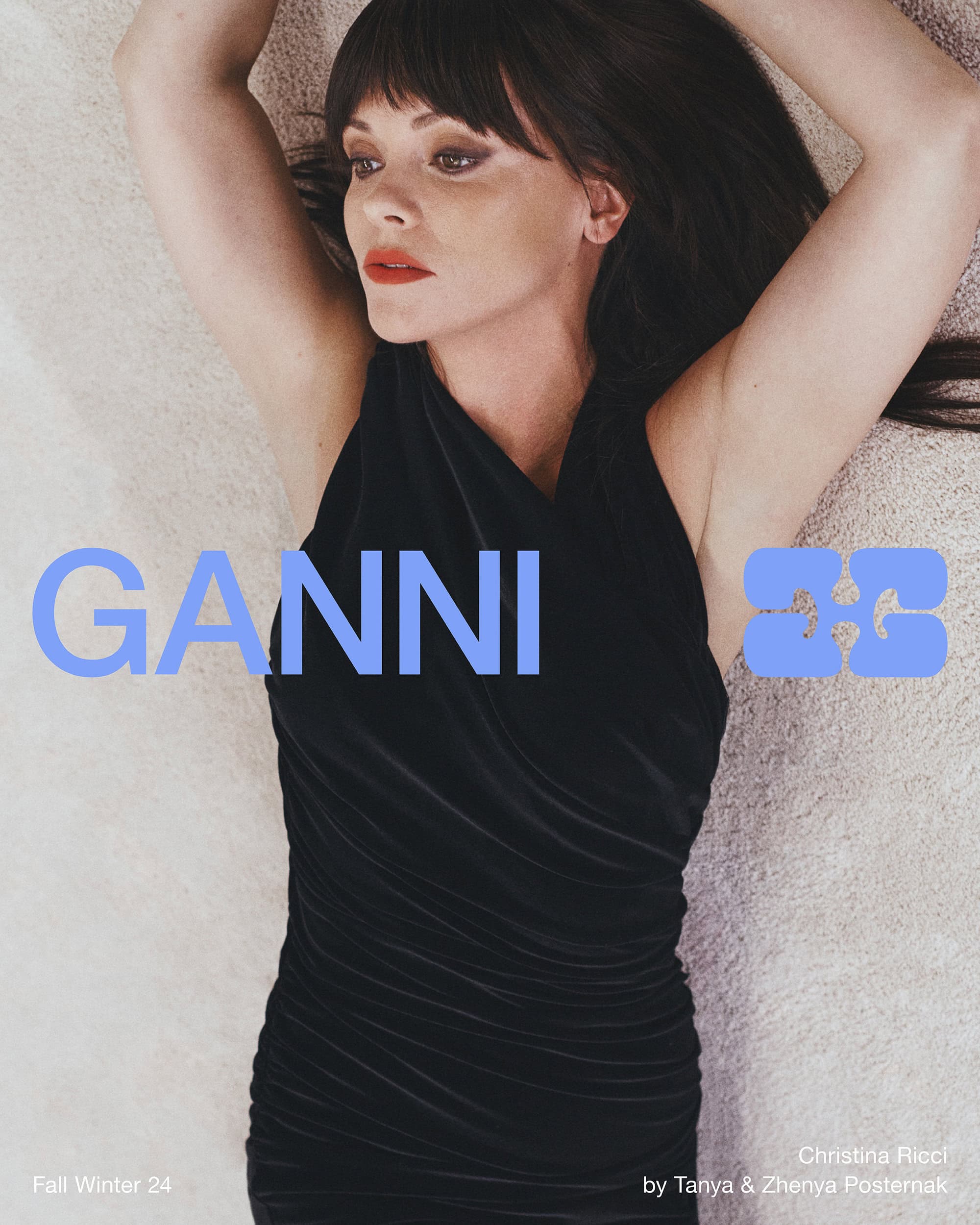 Christina Ricci wearing a black dress lying on a textured white surface for Ganni Fall 2024 campaign
