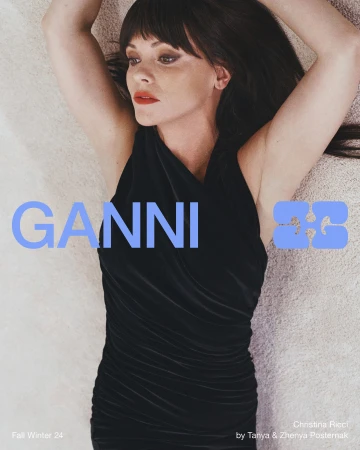 Christina Ricci wearing a black dress lying on a textured white surface for Ganni Fall 2024 campaign