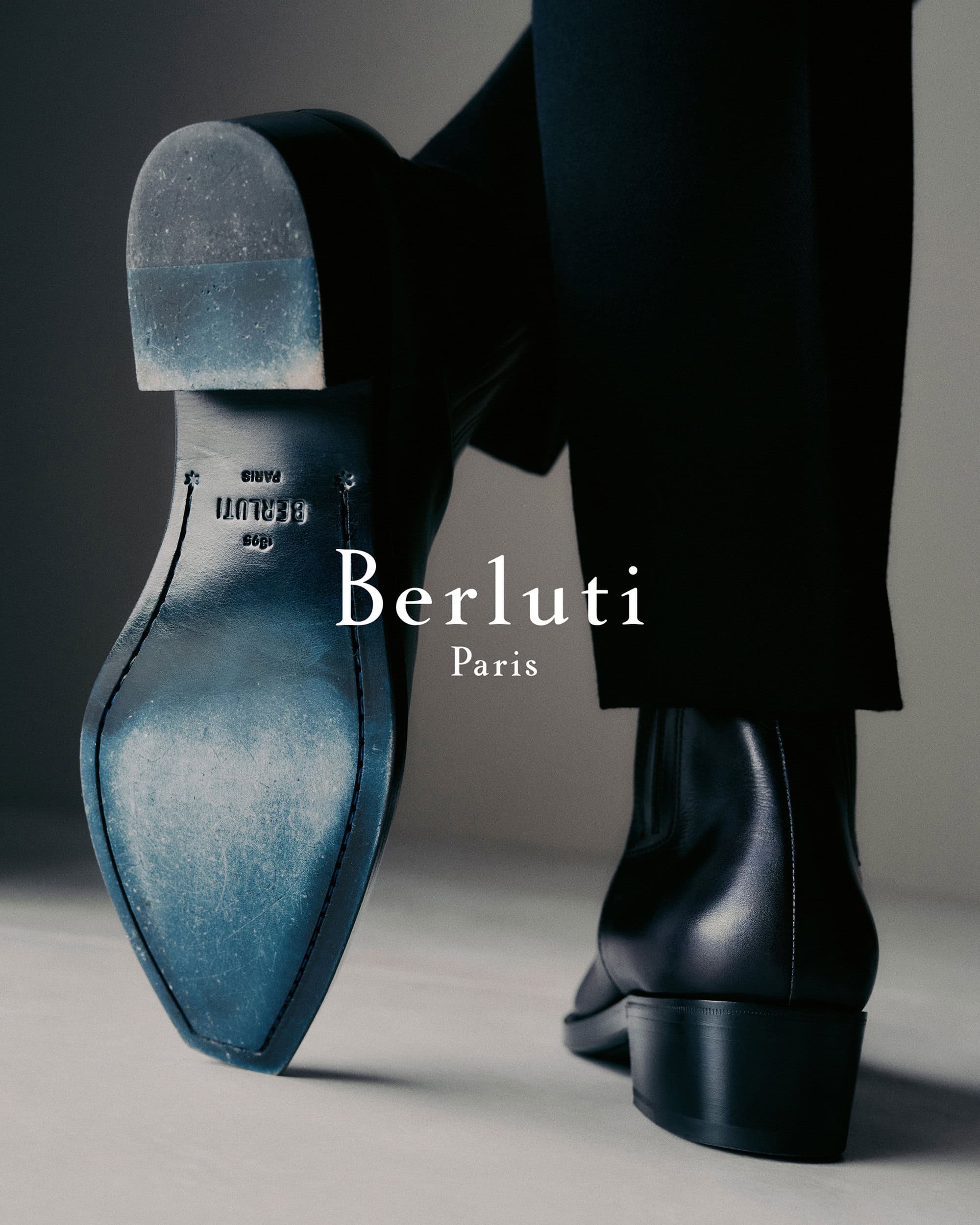 Close-up of leather dress shoes and dark trousers against a neutral background for the Berluti Fall 2024 campaign