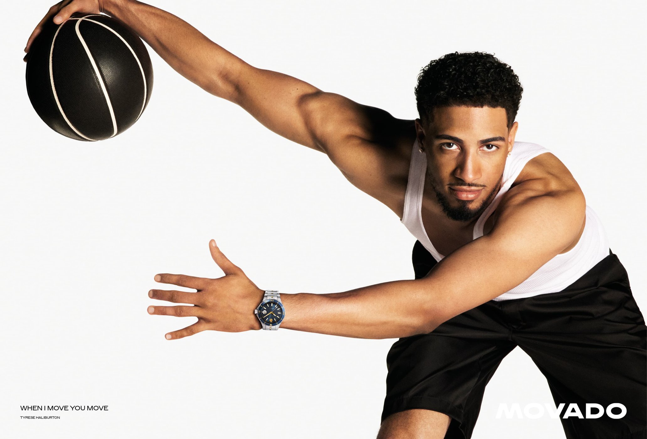 Tyrese Haliburton wearing a white tank top and holding a basketball against a white seamless backdrop for Movado