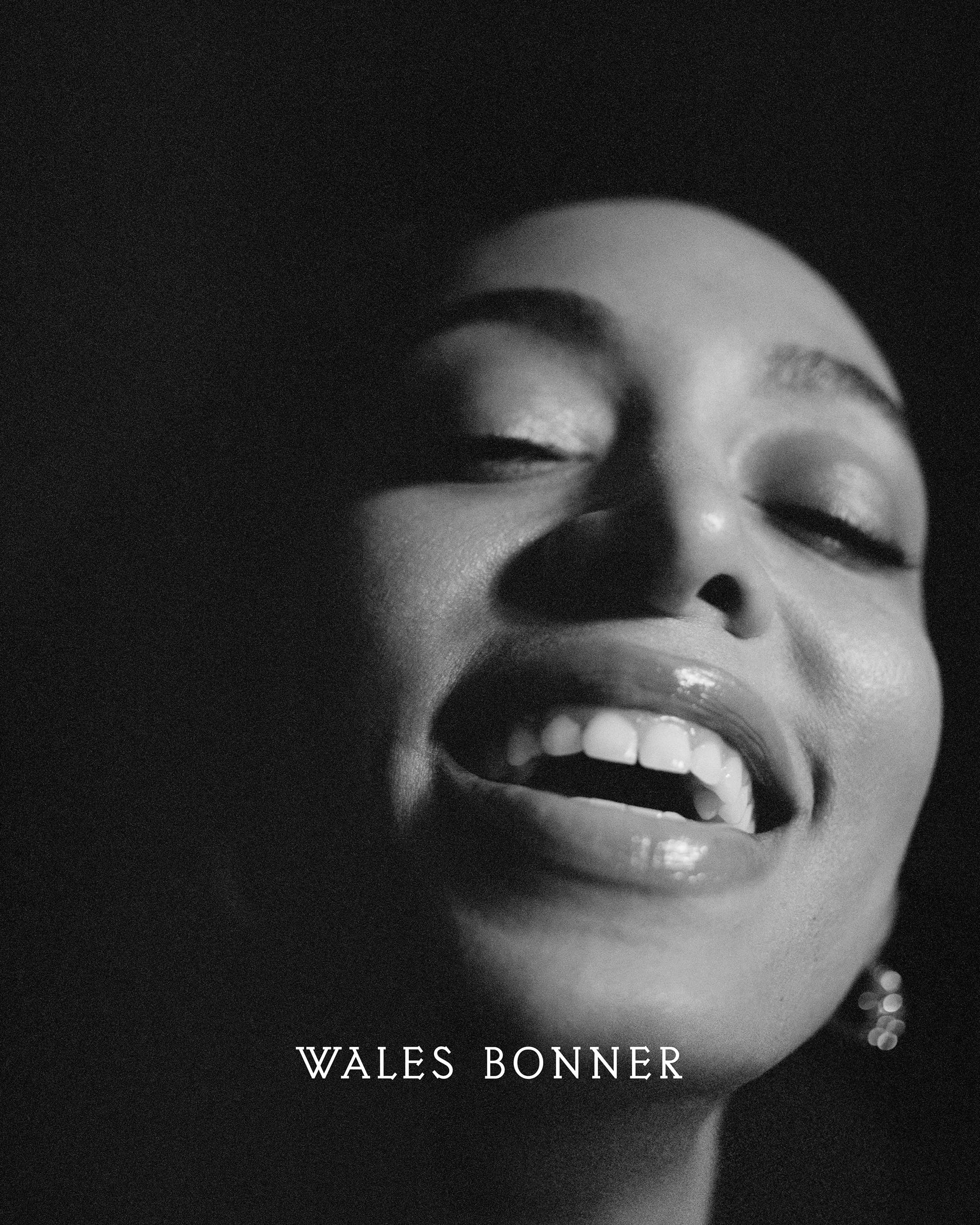 Close-up monochrome portrait of a smiling woman laughing with head tilted back for Wales Bonner campaign