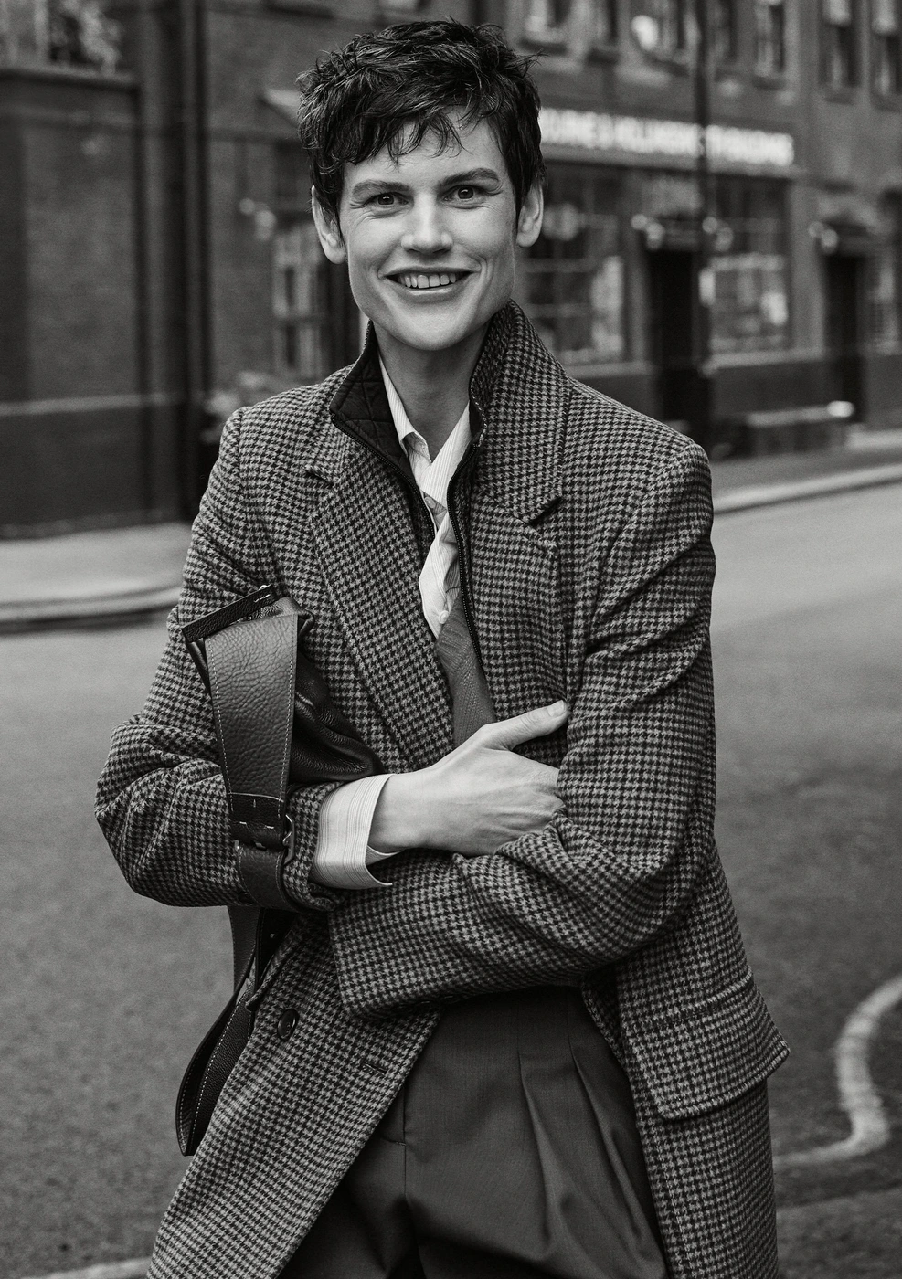 Model Saskia de Brauw in houndstooth coat holding a bag on a London street for ME+EM Fall 2024 ad campaign