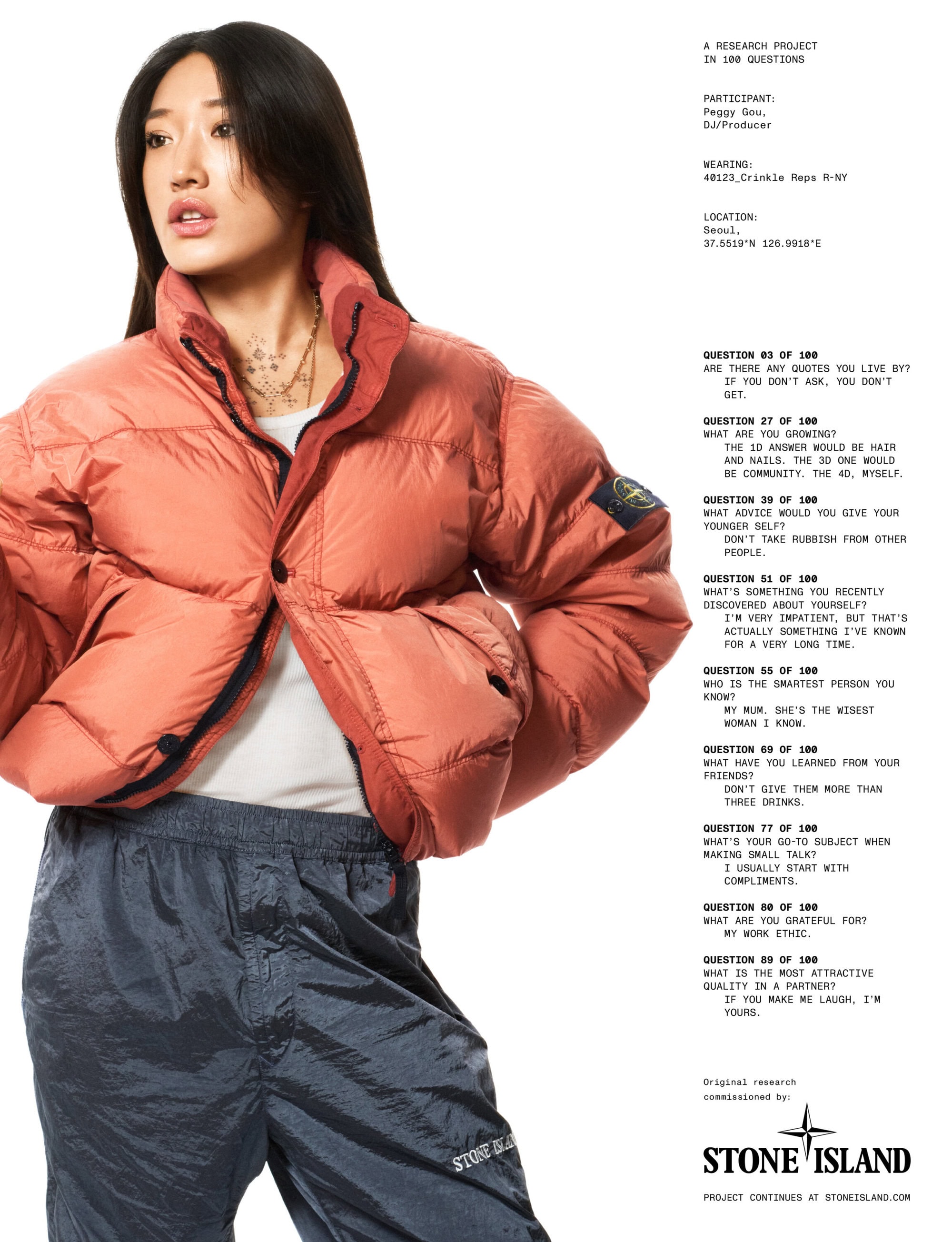 Peggy Gou wearing a rust orange puffer jacket against a solid white studio background.