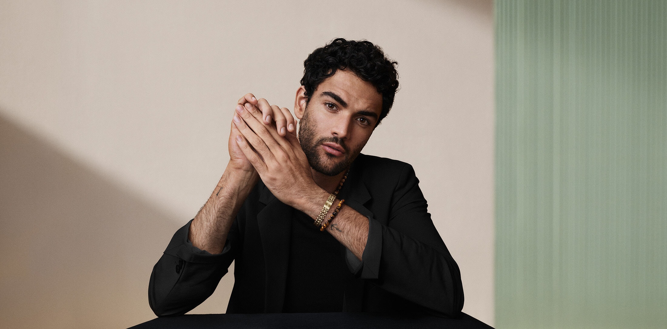 Matteo Berrettini wearing a black blazer with hands clasped in studio setting for BOSS Fall 2024 campaign