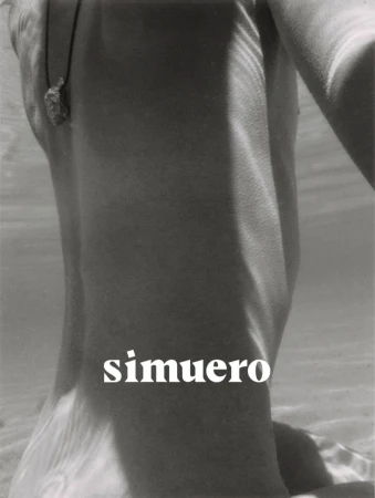 Monochrome underwater close-up of a person wearing a cord necklace with a pendant for Simuero