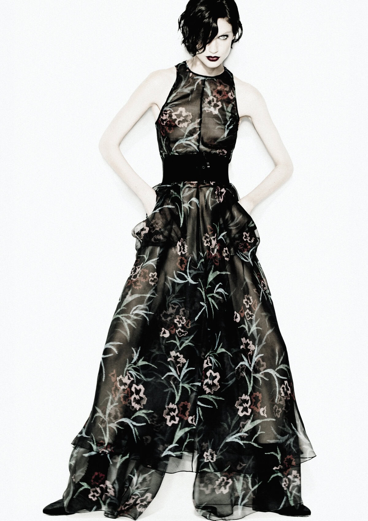 Model wearing a sheer black floral gown against a bright white background for the Giorgio Armani Fall 2024 campaign
