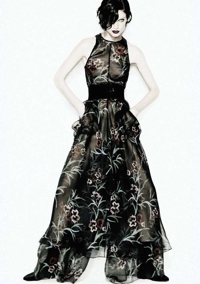 Model wearing a sheer black floral gown against a bright white background for the Giorgio Armani Fall 2024 campaign