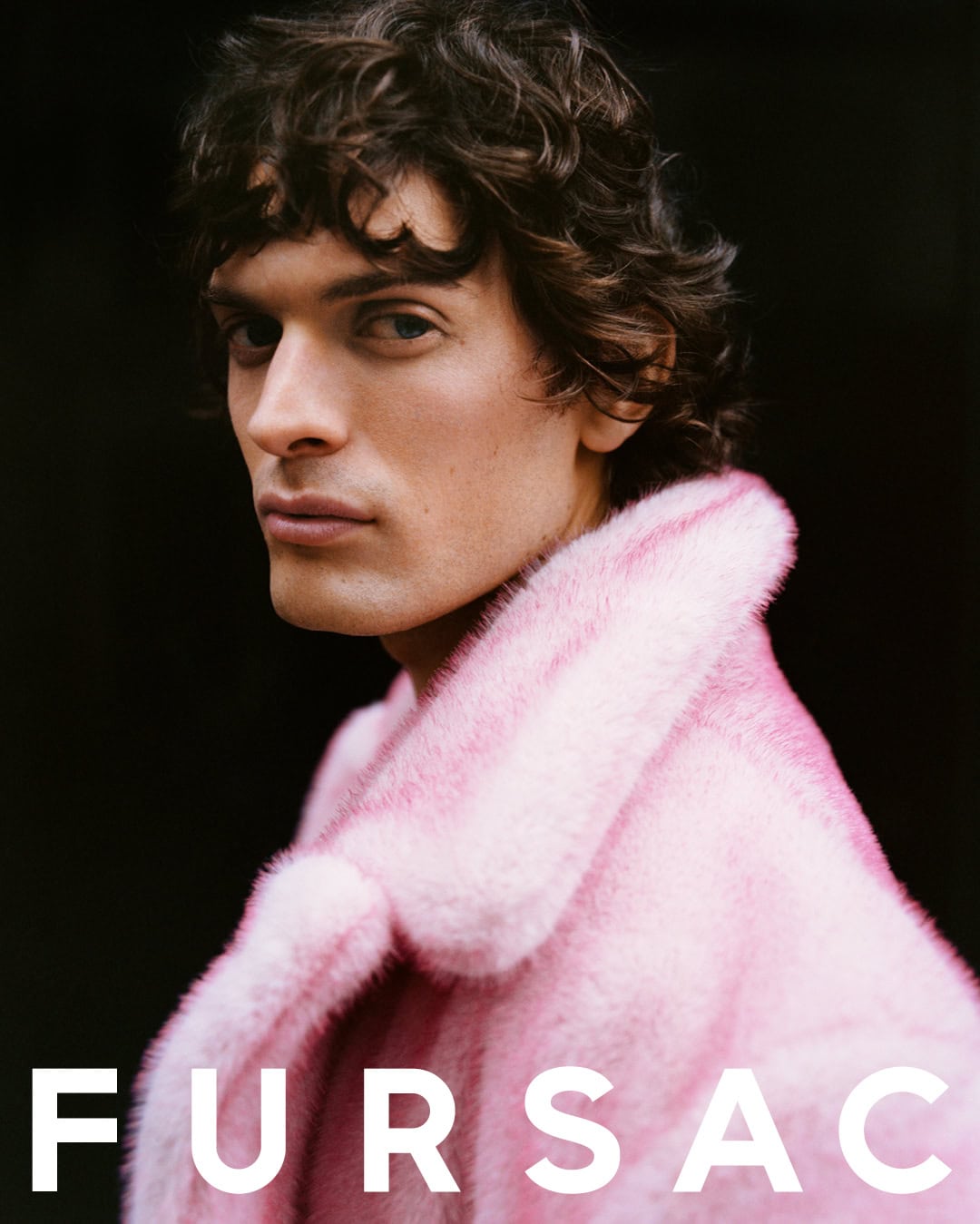 Portrait of a man wearing a bright pink furry coat against a dark background with Fursac branding text at the bottom.
