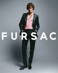 Model wearing a dark pinstripe suit over a pink western shirt against a plain grey background with large white brand text overlay.