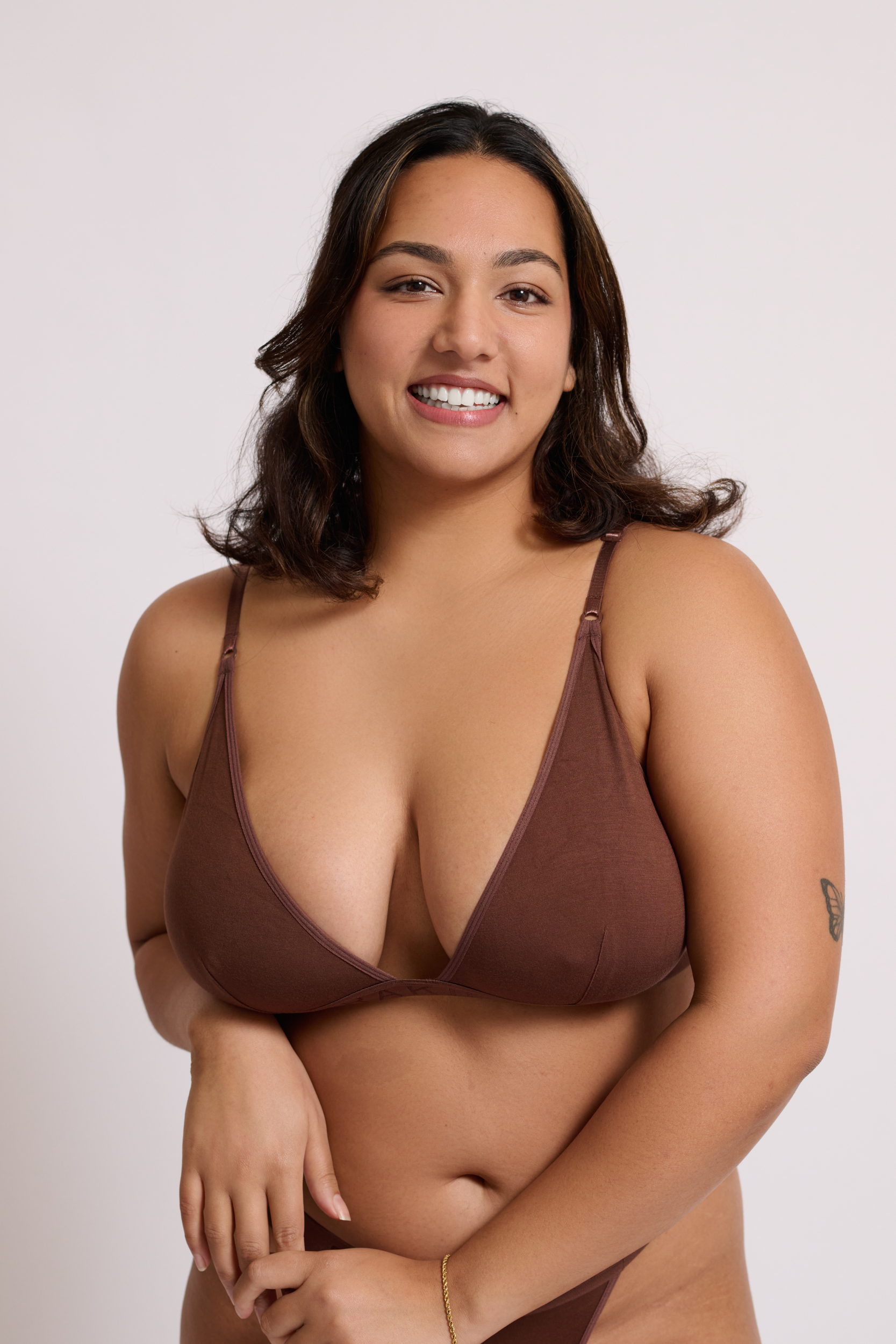 Model Shrayaarya wearing brown lingerie against a plain white studio background in a portrait by Juan Santamaria.