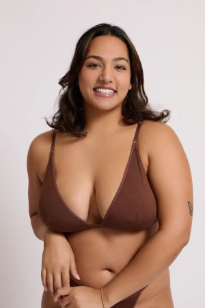Model Shrayaarya wearing brown lingerie against a plain white studio background in a portrait by Juan Santamaria.