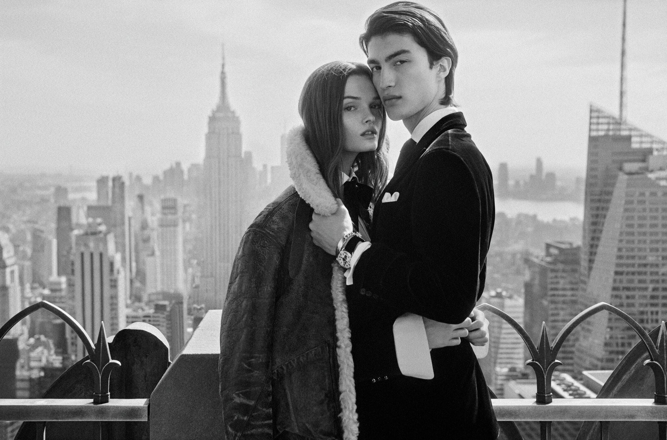 Black and white portrait of a couple on a New York rooftop with the Manhattan skyline in the background.
