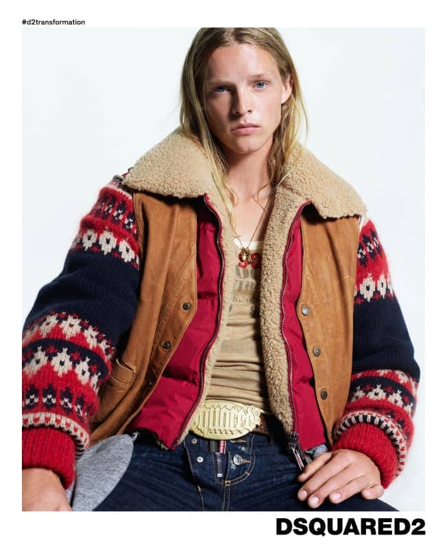 Model wearing a shearling-collared jacket and patterned knit sleeves against a white background
