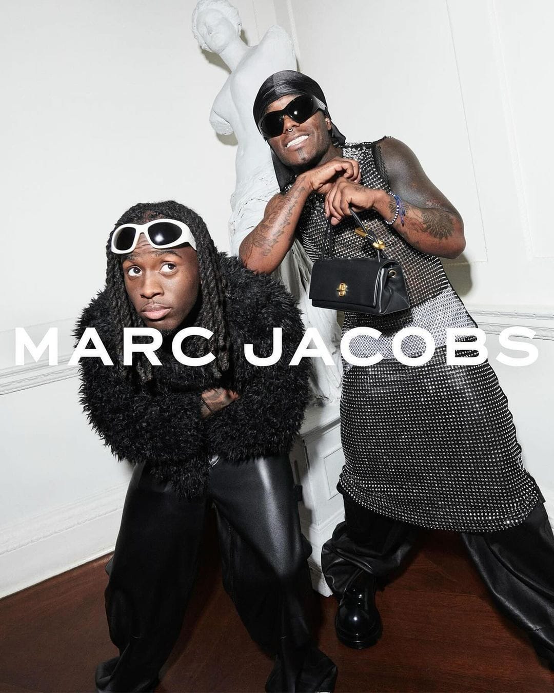 Kai Cenat and Lil Uzi Vert pose for Marc Jacobs Fall 2024 ad campaign wearing black designer apparel and sunglasses in a white interior