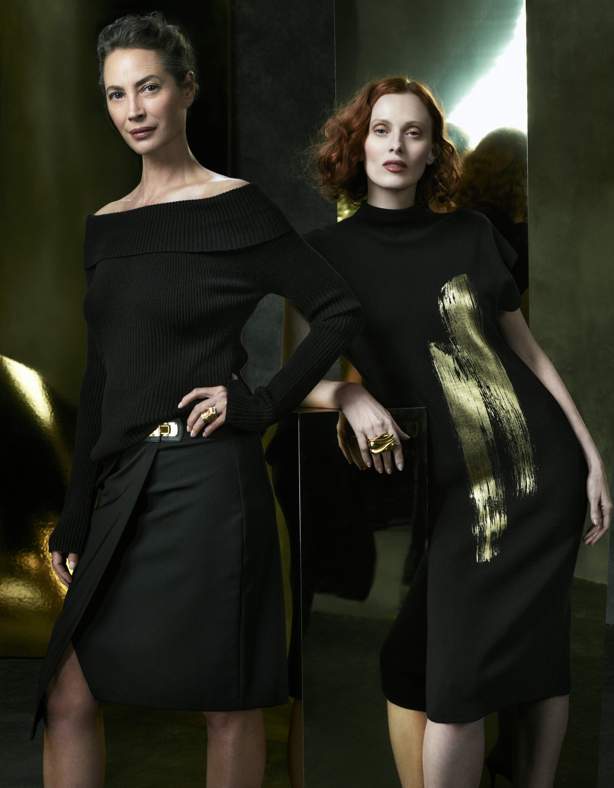 Two women modeling black dresses and knitwear in a campaign photographed by Mikael Jansson for Donna Karan.