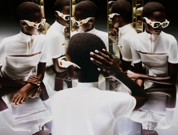 Black woman wearing white top and white sunglasses reflected in multiple mirrors for Casablanca Fall 2024 campaign