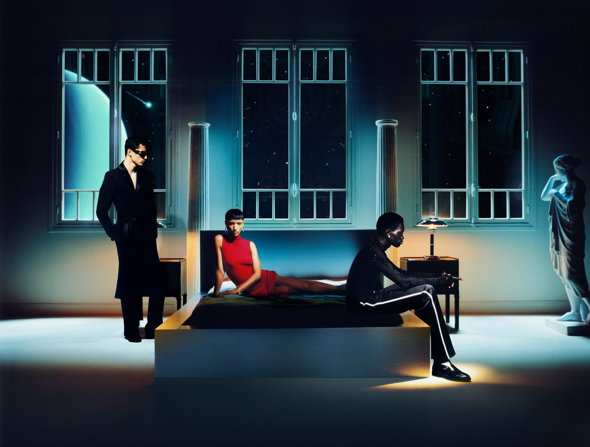 Three models posed in a theatrical bedroom set with celestial windows, for the Casablanca Fall 2024 campaign.