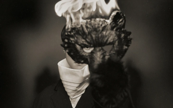 Model wearing a dark sculpted animal mask and white high-collared neckpiece for Songzio fall 2024 campaign