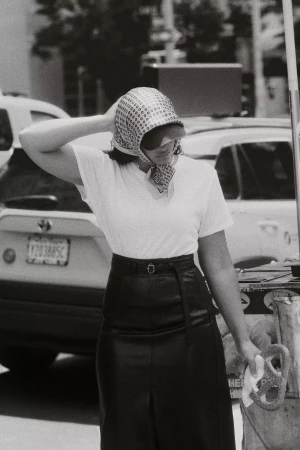 Model wearing a patterned headscarf and dark skirt standing outdoors in New York City for the Anthropologie Fall 2024 Ad Campaign.