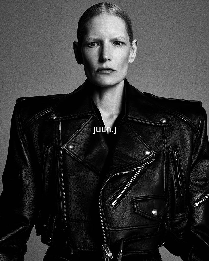 Kirsten Owen in a black leather jacket with structured shoulders against a neutral grey studio background for Juun.J Fall 2024 campaign.