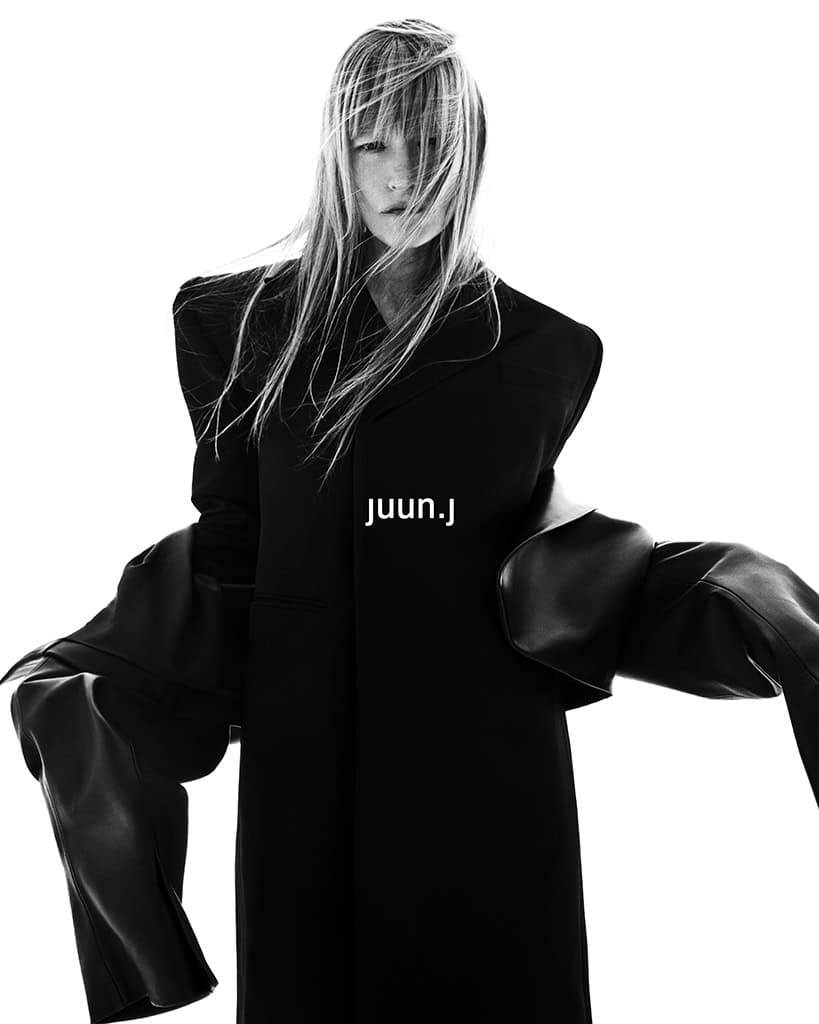 Kirsten Owen wearing a structured black coat for Juun.J Fall 2024 campaign against a white background