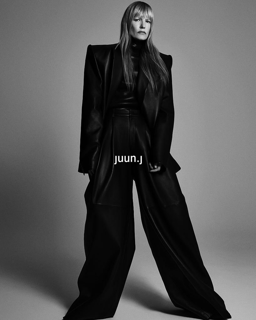 Model Kirsten Owen in an oversized black structured suit against a plain grey background for Juun.J Fall 2024 campaign.