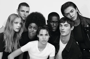 Black and white portrait of a group of diverse models posing together against a light background for Calvin Klein.