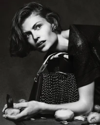 Model Bibi Breslin holding potatoes with a patterned black bag for Byredo photographed by Luis Alberto Rodriguez.