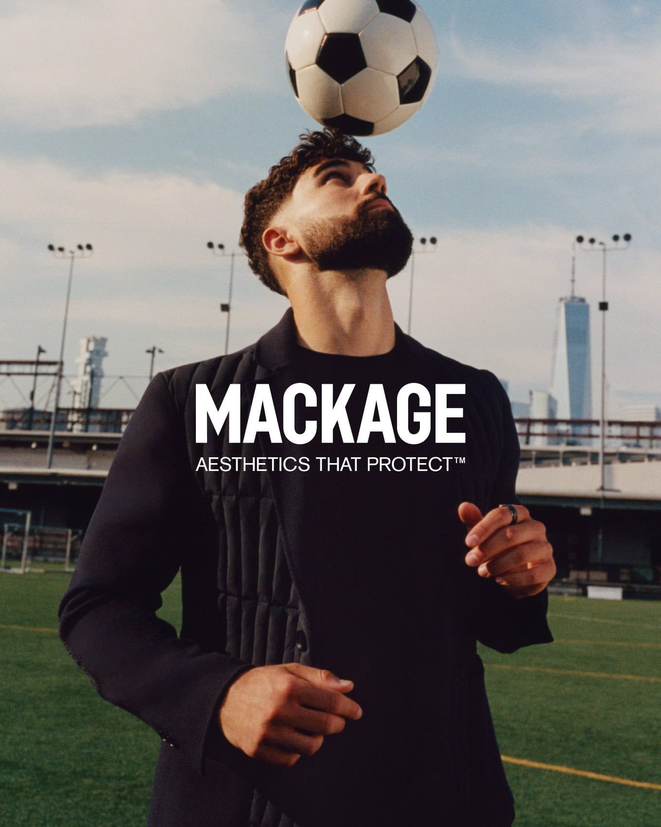 Joško Gvardiol balancing a soccer ball on his head wearing a black jacket on a sports field for Mackage