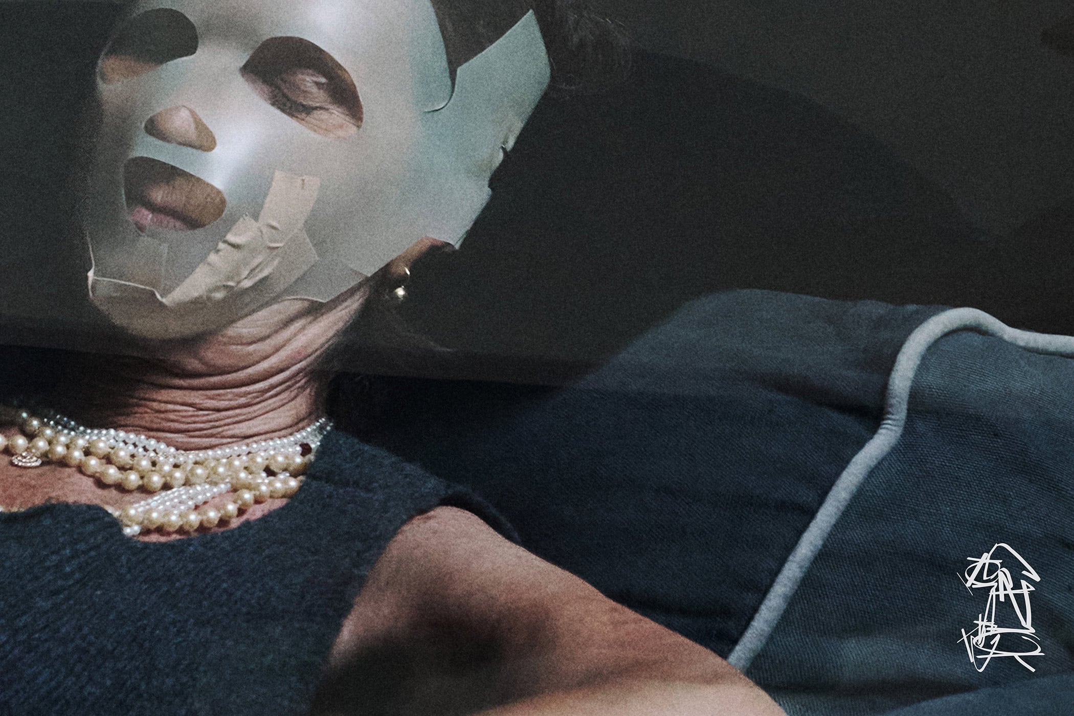 Elderly woman wearing a pale mask and layered pearl necklaces for GR10K Incognito campaign