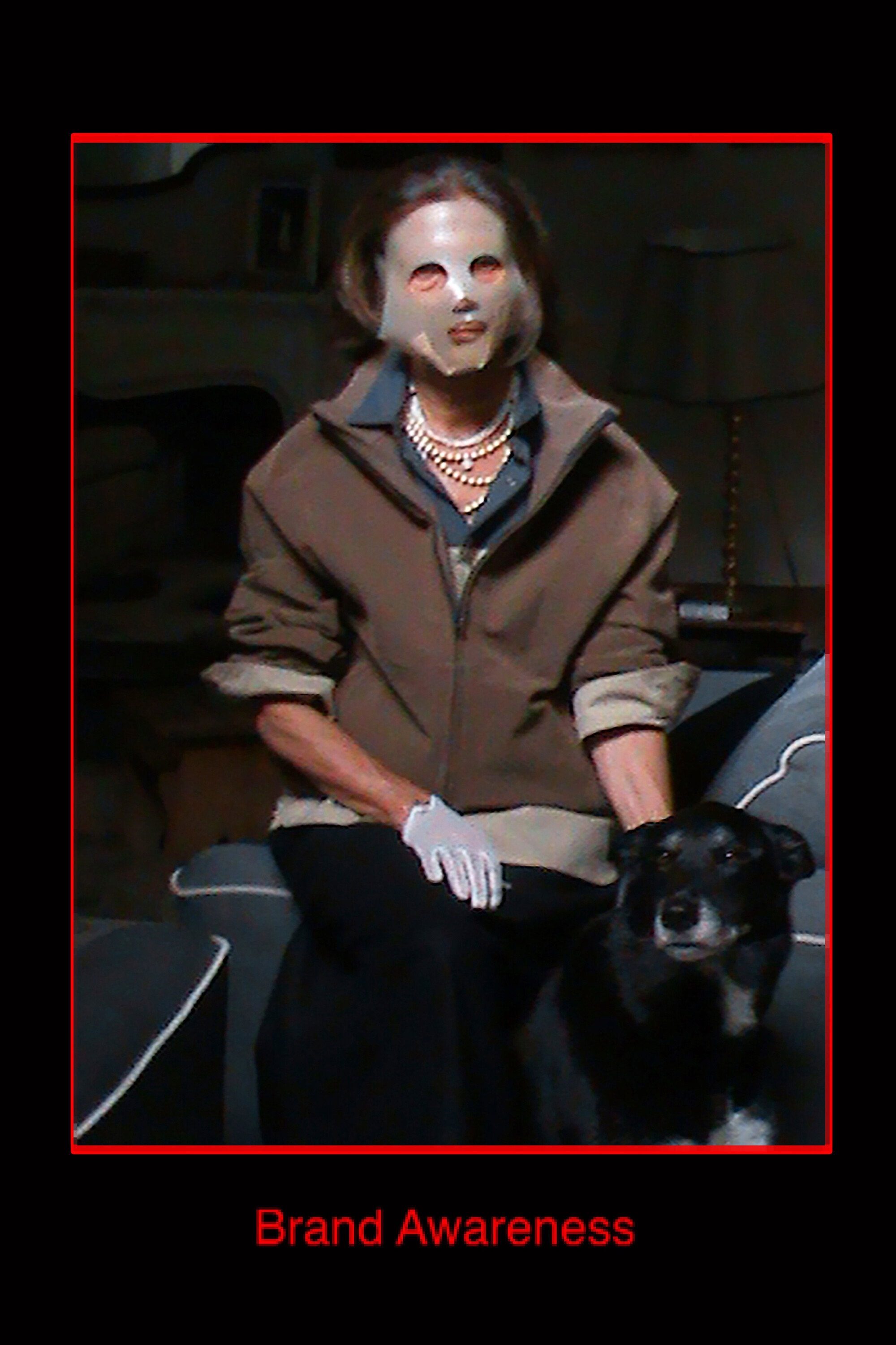 Woman wearing a face mask and brown jacket sitting on a sofa with a black dog for GR10K Incognito campaign.