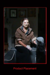 An older woman wearing a face mask and brown jacket sitting indoors with a black dog for the GR10K Incognito campaign.