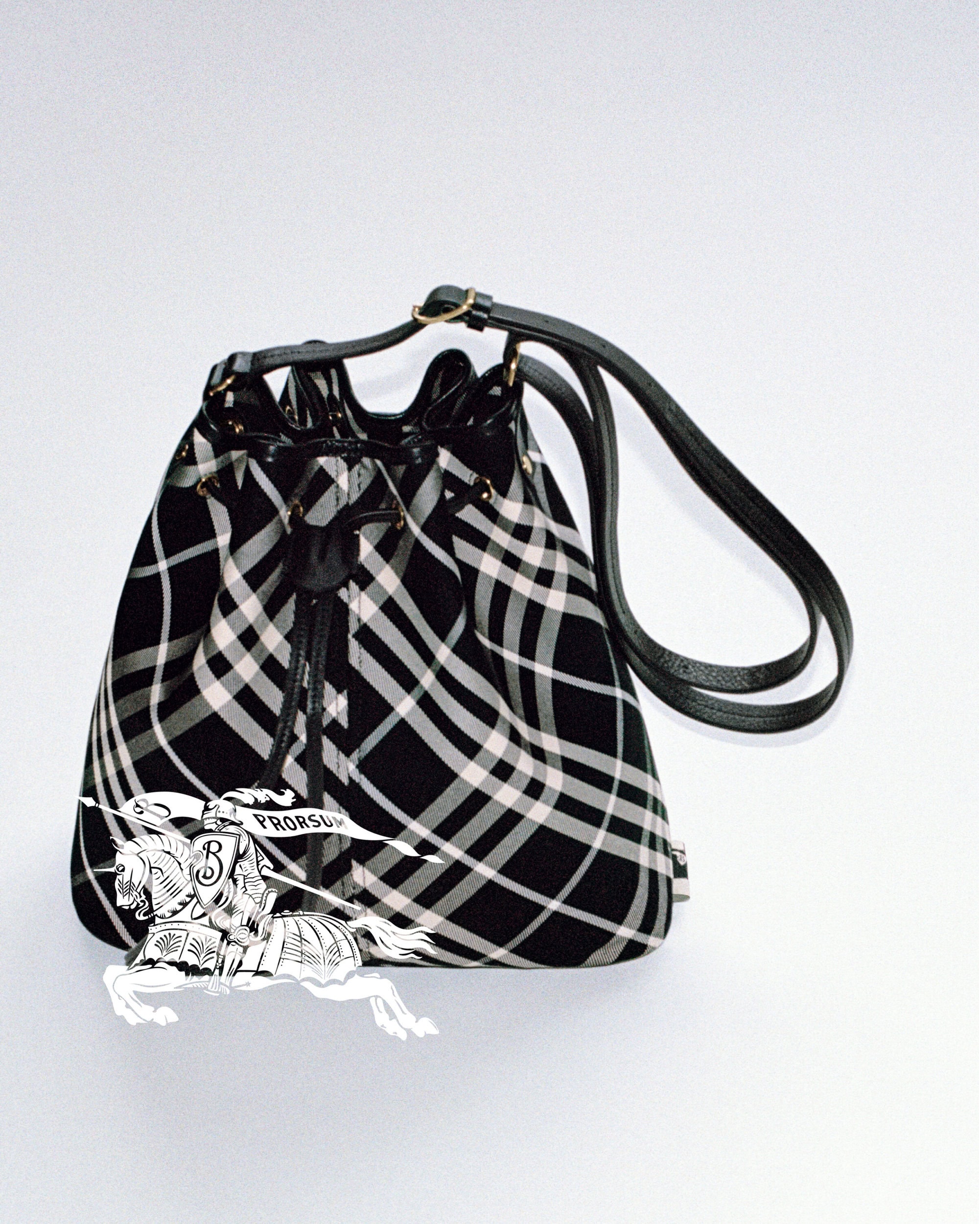 Burberry black and white plaid bucket bag with black leather strap against a clean white background