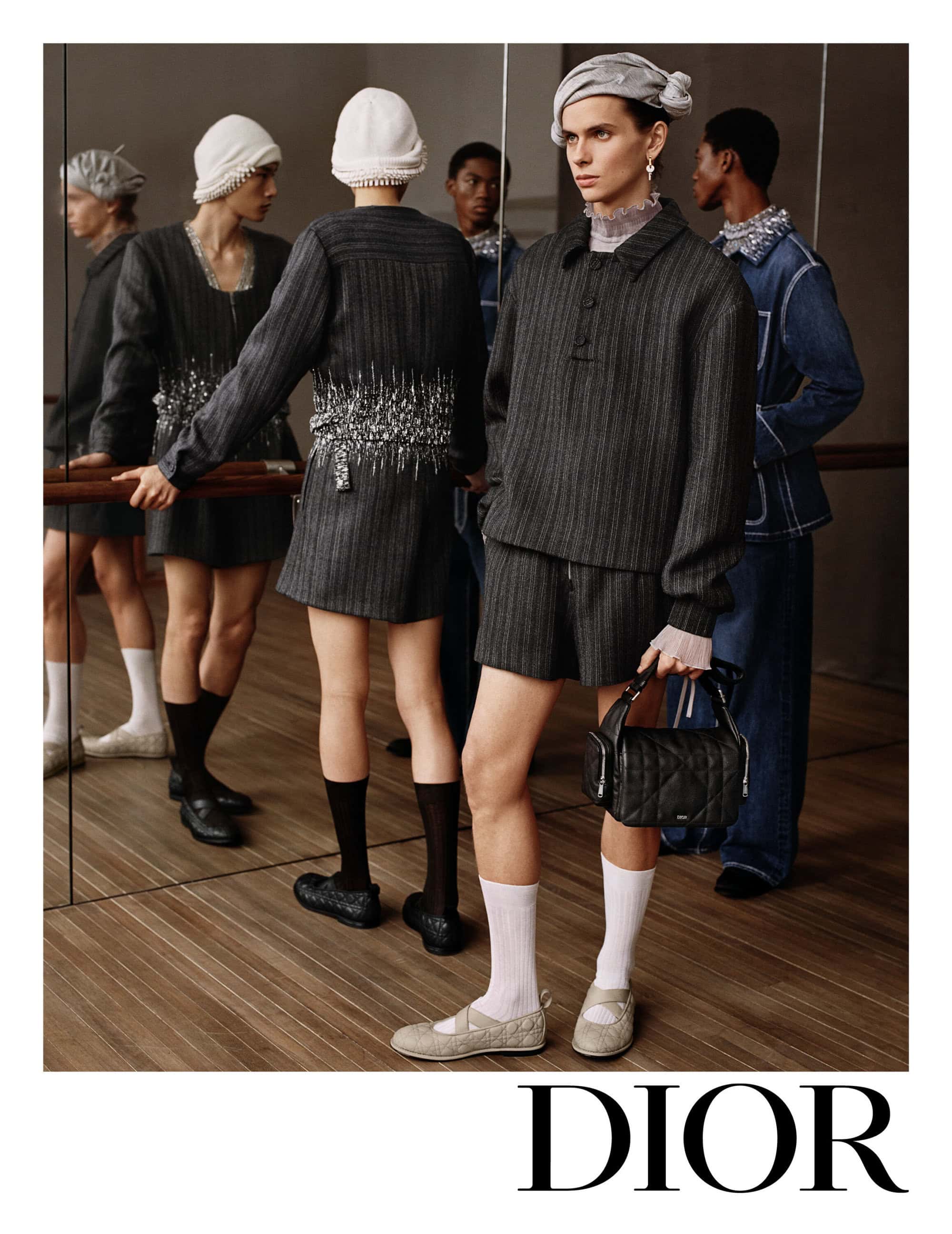 Fashion editorial featuring a group of models wearing elegant grey and white ensembles in an indoor setting with soft lighting.