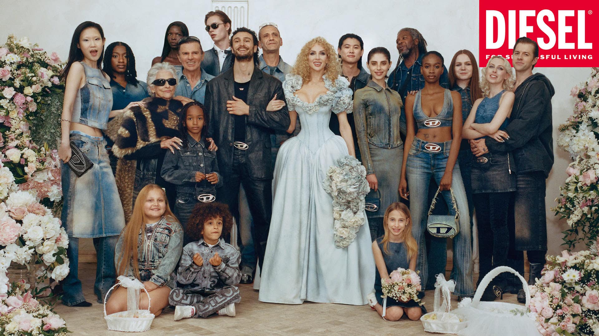 Large group of people posing for a Diesel brand fashion shoot with a bride in the center, set against a minimal white background.