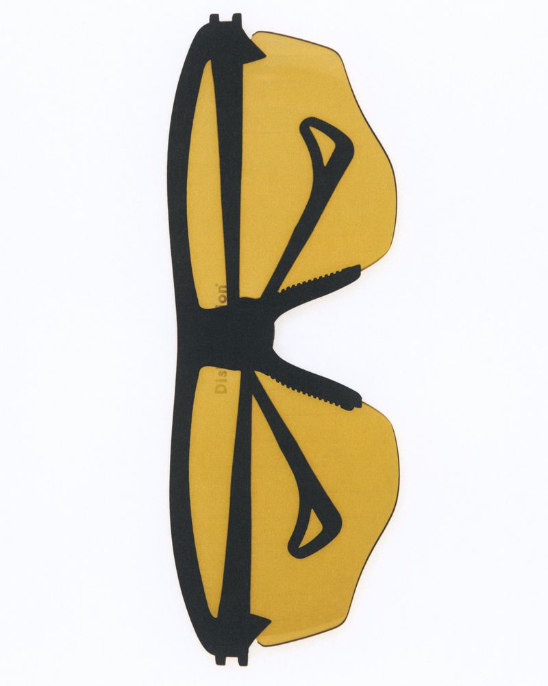 Overhead shot of yellow and black eyewear components with modern design on a white backdrop, showcasing sleek lines and geometric shapes.