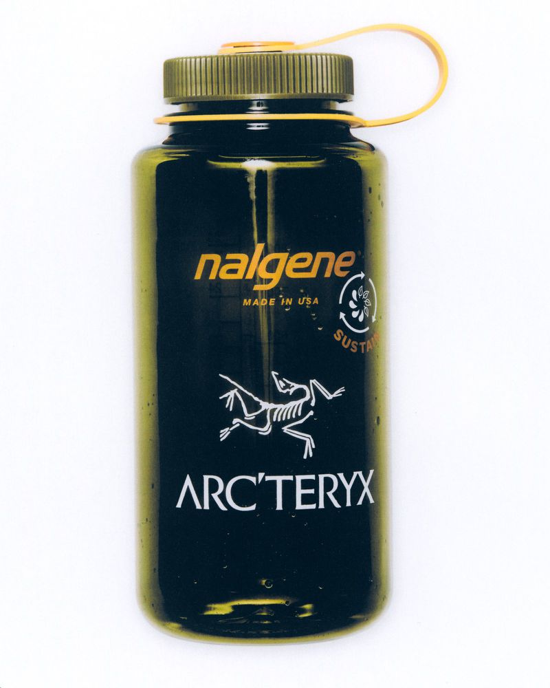 Dark green Nalgene water bottle with a yellow cap, featuring the Arc'teryx logo, set against a plain white background.