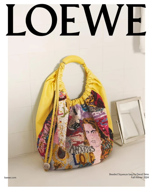 Loewe Beaded Squeeze bag featuring artwork on a bathroom sink against a tiled white wall, showcasing fashion and brand aesthetic.