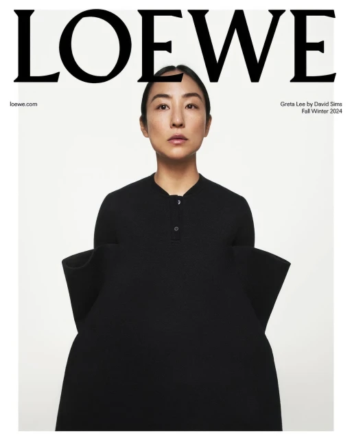 Fashion editorial shot featuring an Asian woman with sleek hair wearing a black dress and standing against a clean white background.