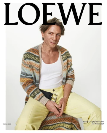 Daniel Craig wearing a patterned cardigan and yellow trousers against a white background for Loewe.