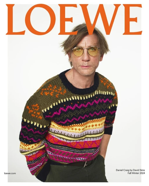 Portrait of Daniel Craig on the cover of Loewe magazine. He is wearing a colorful patterned sweater and yellow tinted glasses.