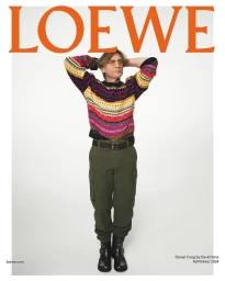 Daniel Craig wearing a patterned sweater and cargo pants against a white background for the Loewe Fall 2024 campaign.