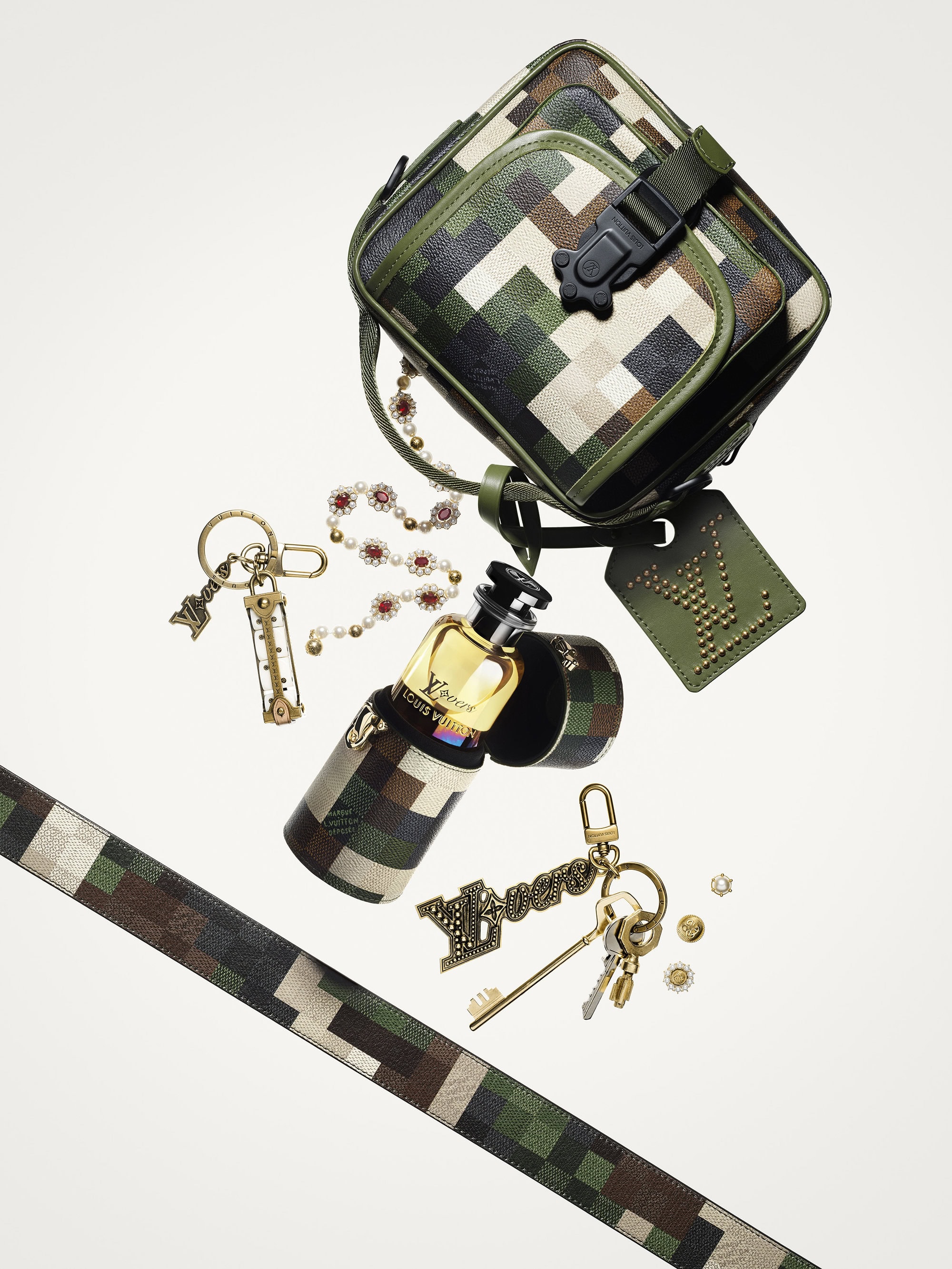 Camouflage patterned Louis Vuitton handbag, perfume bottle, and various accessories floating on a white background in a studio shot.