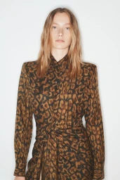 Model wearing a brown and black animal print long-sleeve dress against a plain white background for Scanlan Theodore Winter 2025.