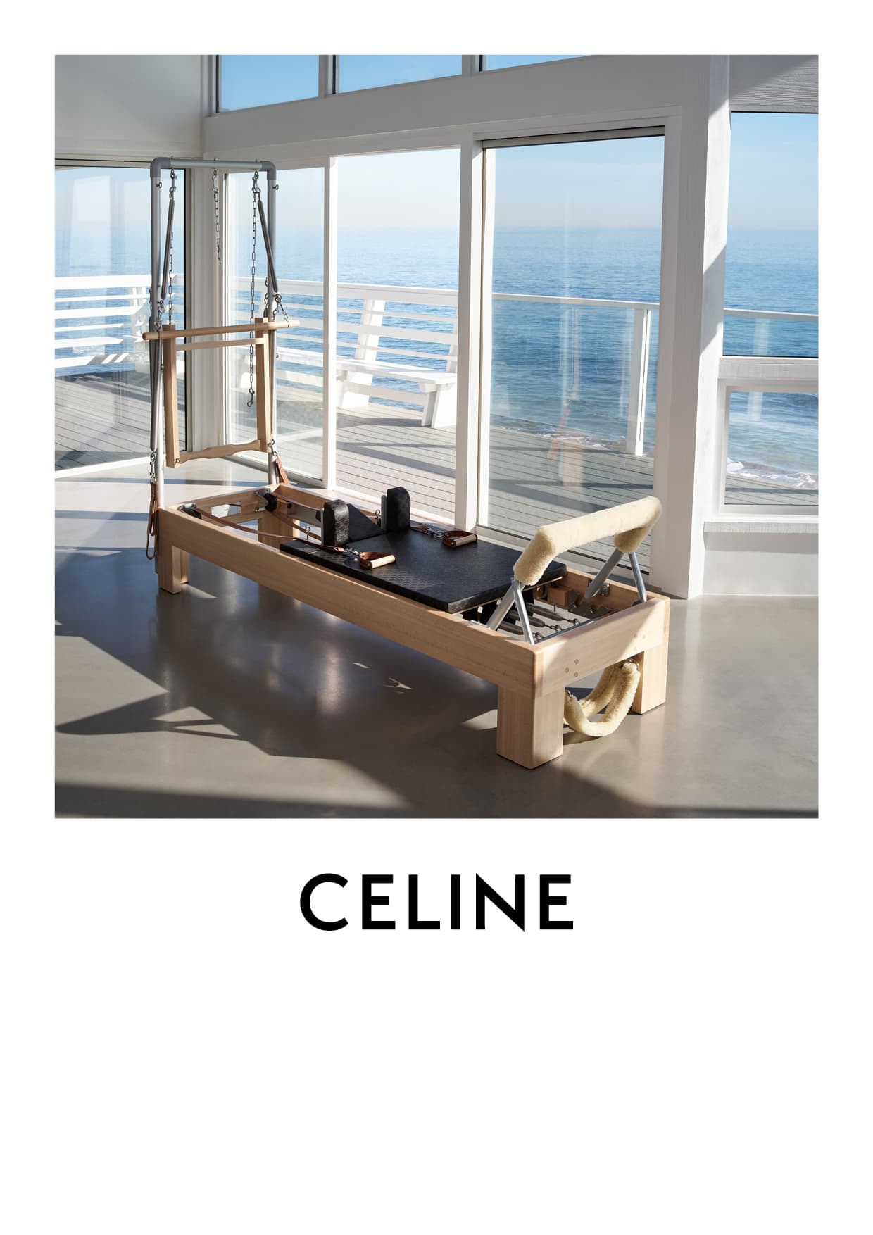 Pilates reformer sits on a light-gray floor, near big windows with an ocean view. Text "CELINE" is at the bottom of the frame.