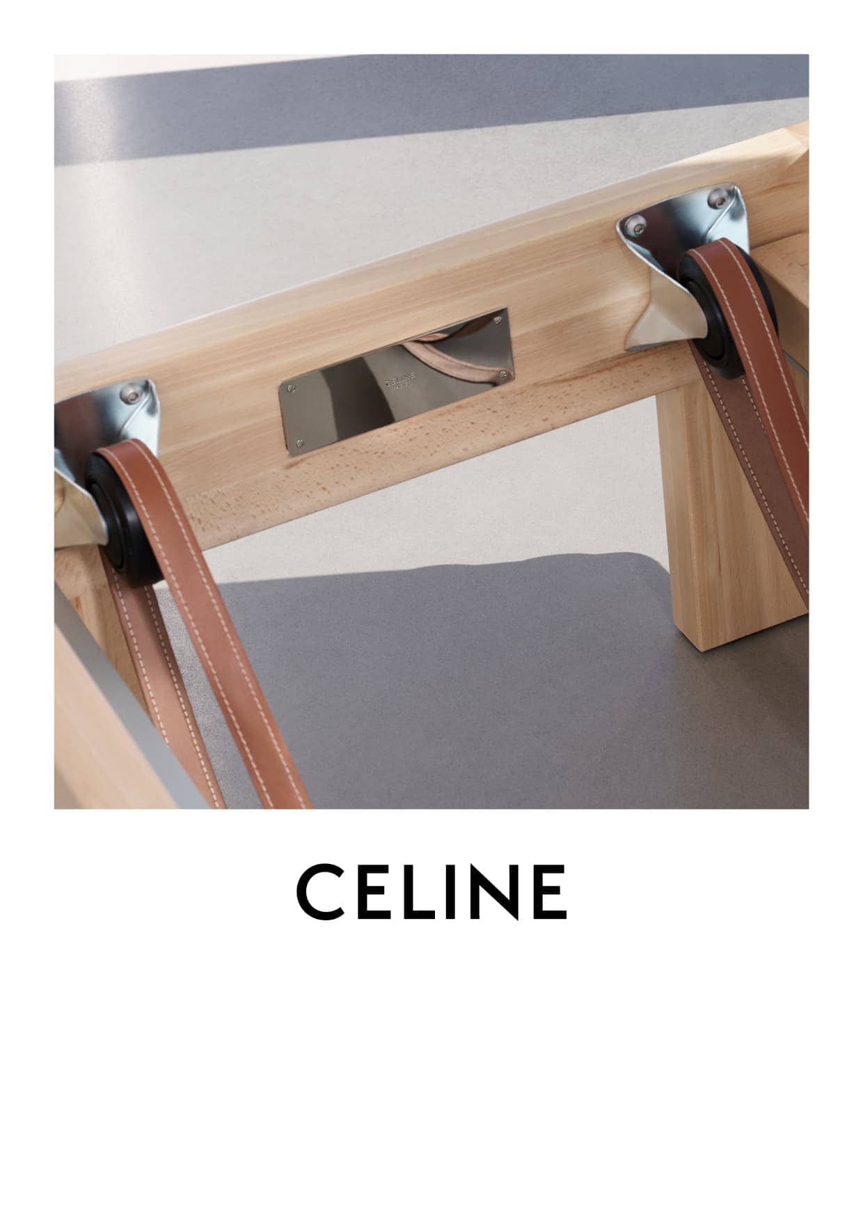 Close-up of light wood chair with brown leather straps, silver hardware, and a gray seat. Branding reads CELINE.