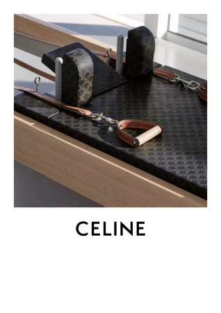 Close-up studio shot of Pilates reformer equipment with a patterned black and brown cover. Wood frame and metal accents are visible.